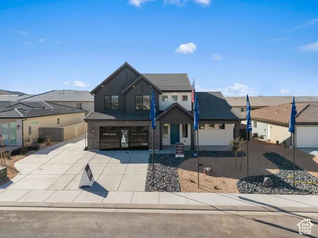 Contemporary exterior featuring a split-level design, attached two-car garage, and a concrete driveway