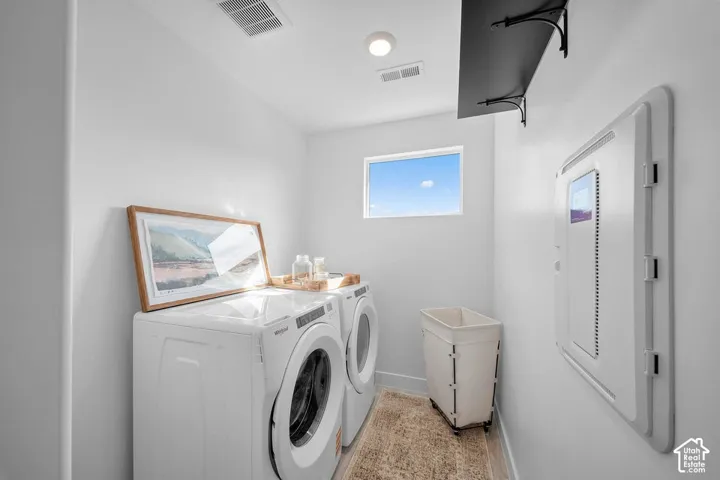Dedicated laundry space with window, overhead lighting, and wall-mounted shelving