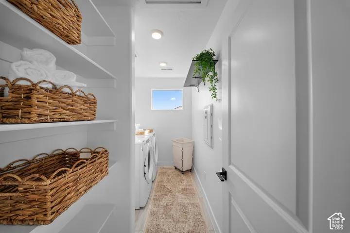 White built-in shelving, recessed ceiling lighting, a window, and a white paneled door with black hardware