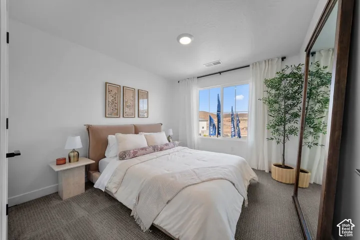 Recessed lighting, wall-to-wall carpeting, and a large window with white curtain rods and white drapes