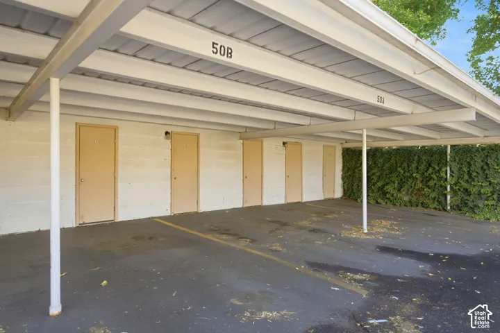 Carport structure with a flat, light-colored roof and supporting columns