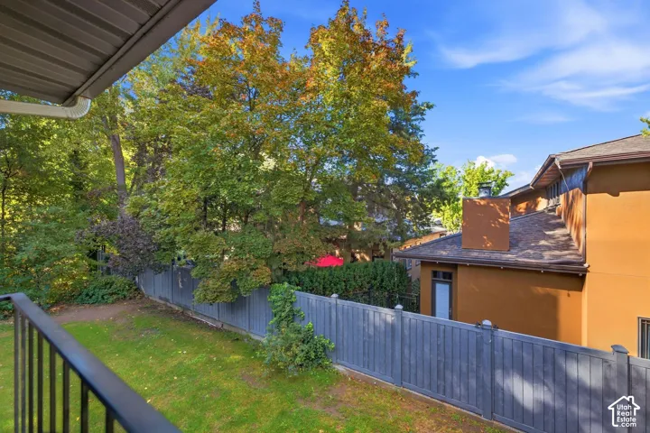 Expansive outdoor space featuring a manicured lawn, established landscaping, and a privacy fence