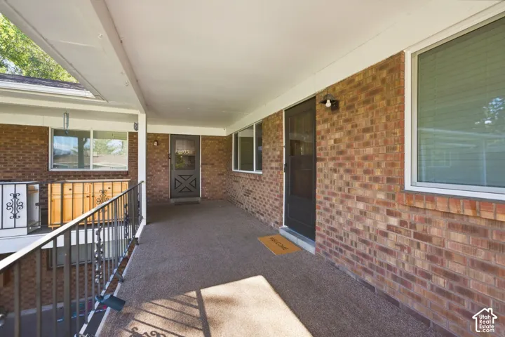 Covered brick exterior with multiple windows and dark entry doors