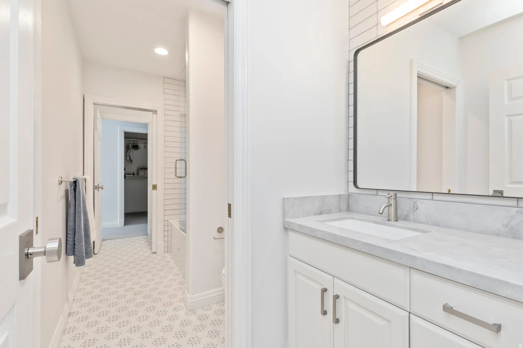 Vanity with a light-toned countertop, under-mount sink, and contemporary faucet