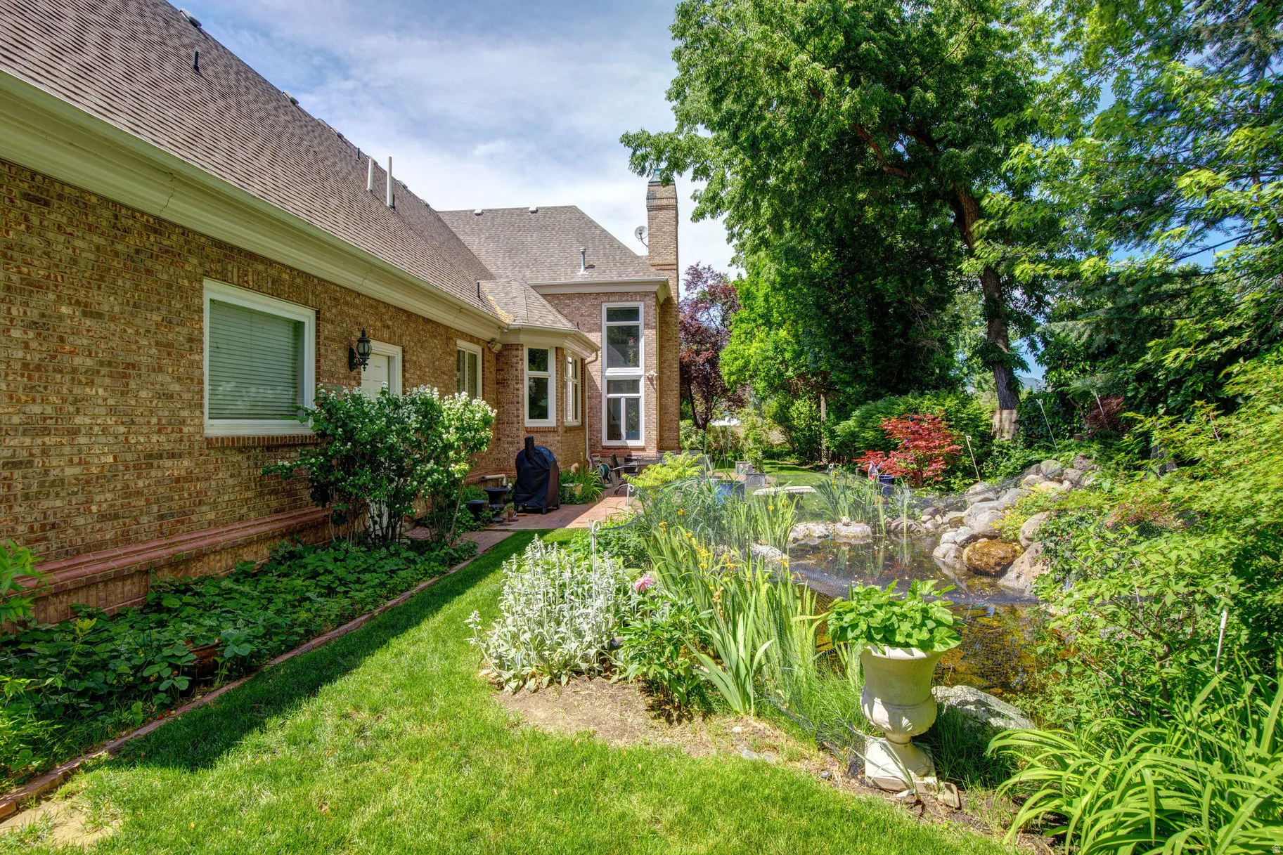 Brick exterior with a gabled roofline, bay window, and a stone chimney
