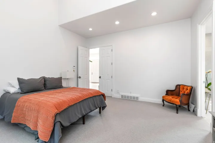 Recessed lighting, light-toned carpeting, white walls, and a double-door entry