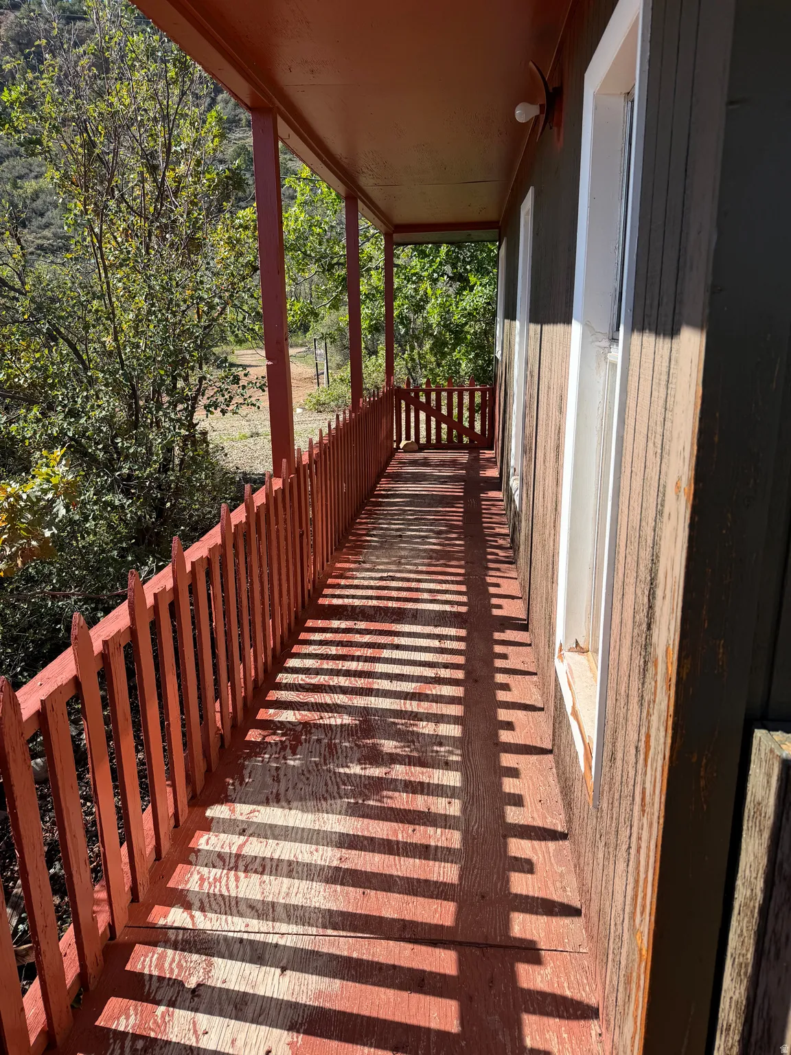 Covered porch with wood flooring and a perimeter railing