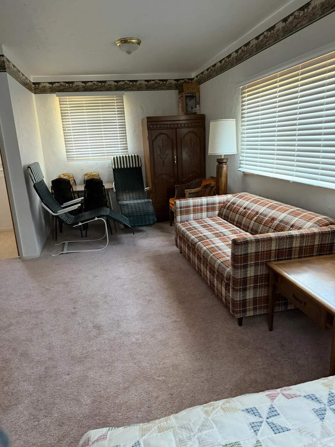 Wall-to-wall carpeting, multiple windows with blinds, ceiling-mounted light fixture, and crown molding with decorative trim