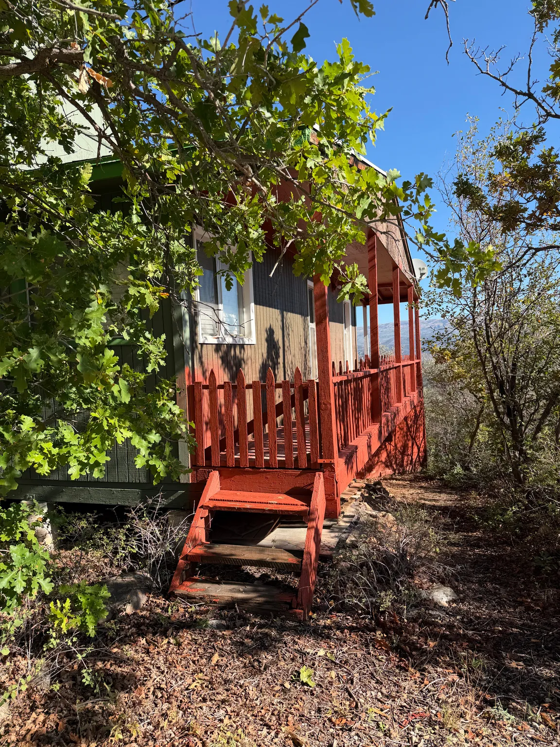 Red-painted front porch featuring a wooden railing and steps
