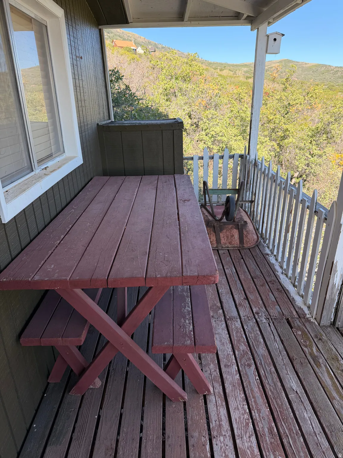 Covered outdoor deck with wood flooring and painted wood siding