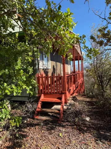 Red-painted front porch featuring a wooden railing and steps