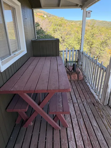 Covered outdoor deck with wood flooring and painted wood siding