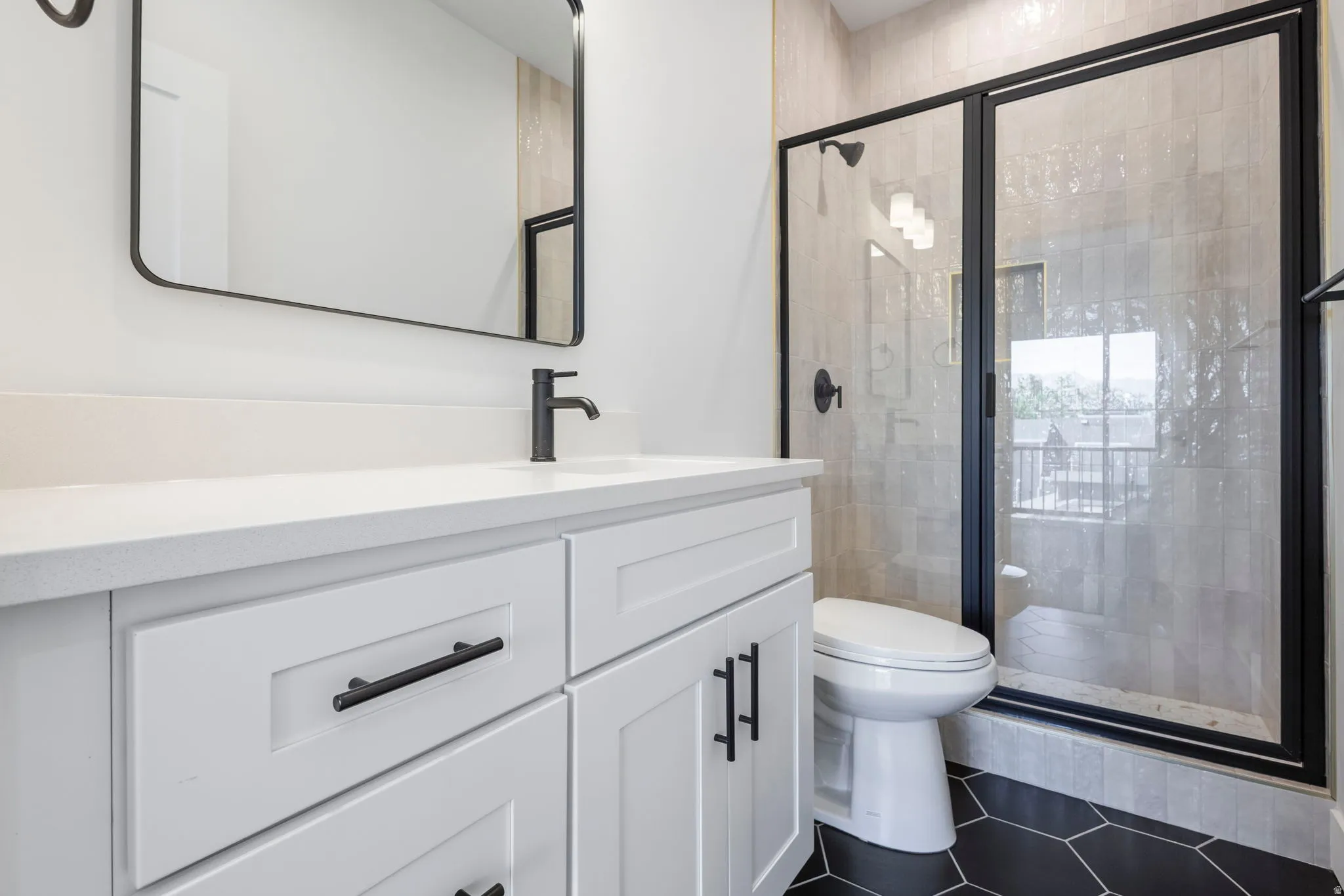 White vanity with matte black hardware, integrated sink, and wall-mounted faucet
