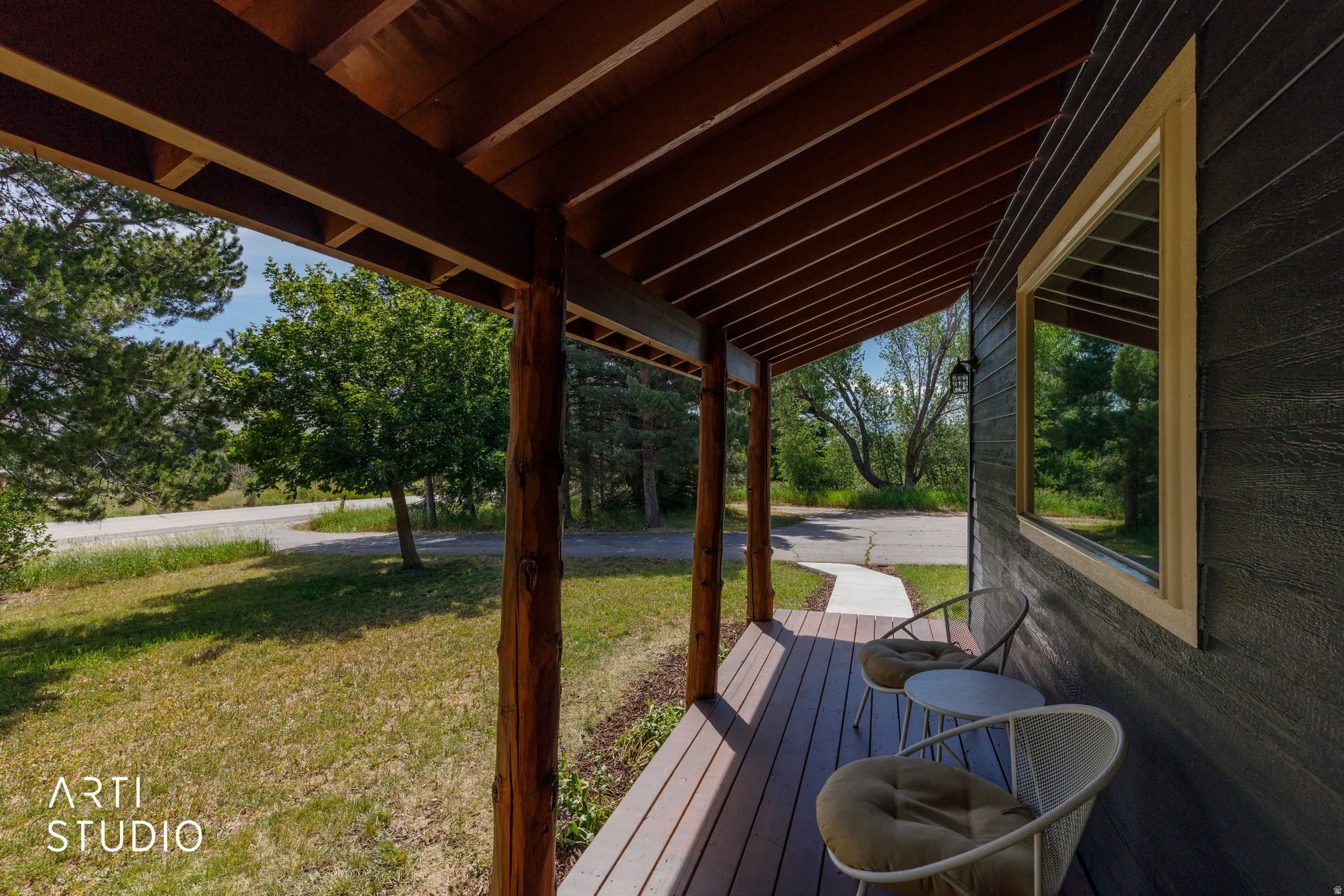 Covered wood-finish porch featuring exposed wood beams and posts