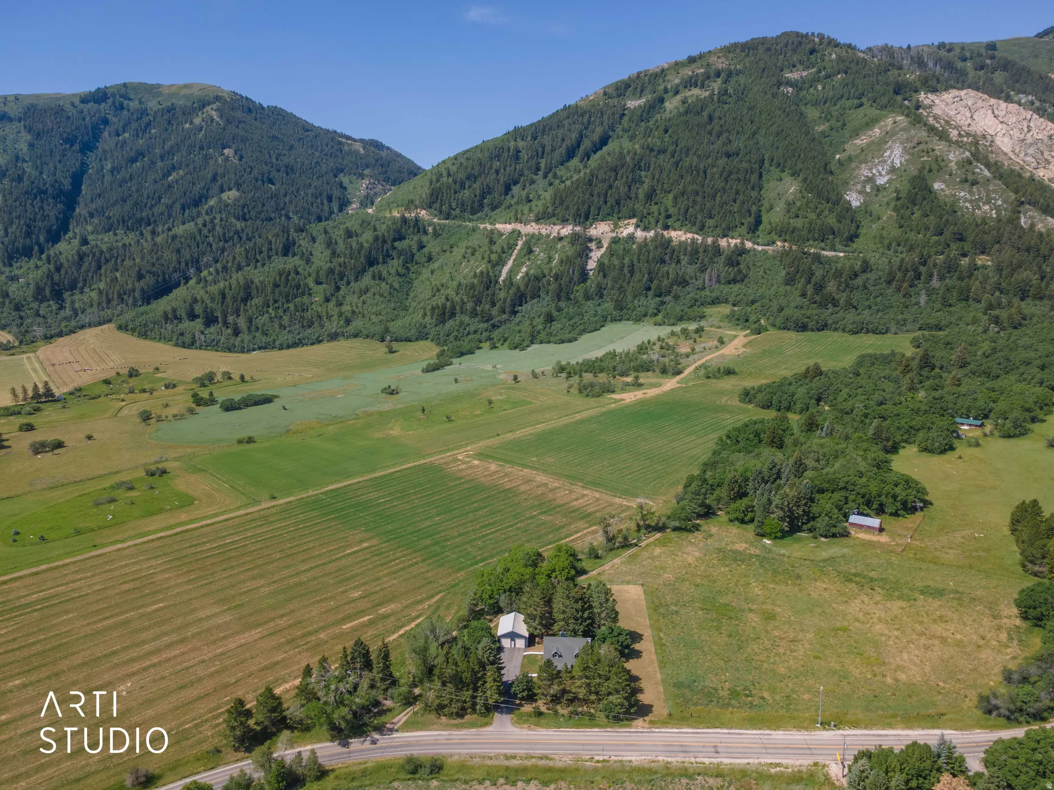 Expansive property featuring a residence, detached barn structure, and surrounding cultivated fields