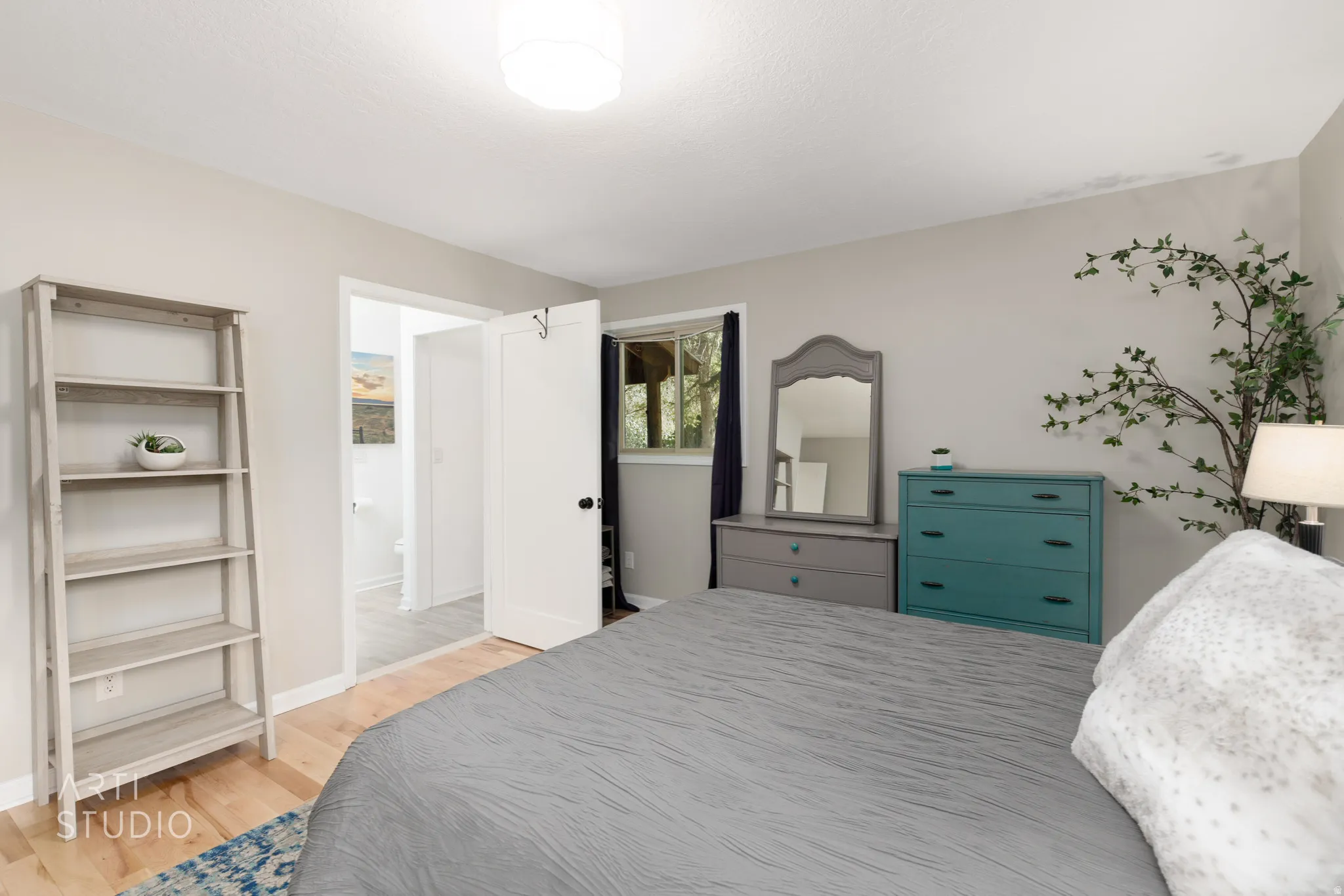 Light wood-finish flooring, neutral wall paint, and a white ceiling-mounted light fixture