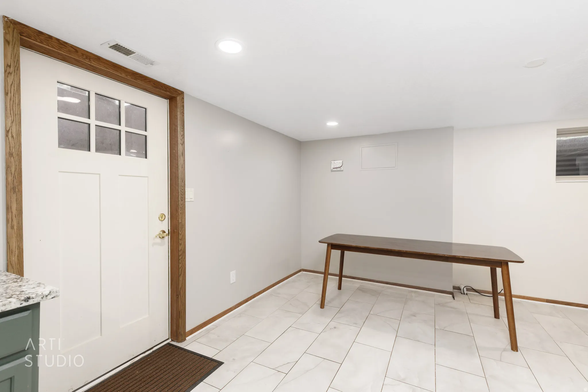 White paneled door with windowpanes, wood-finish trim, and recessed lighting
