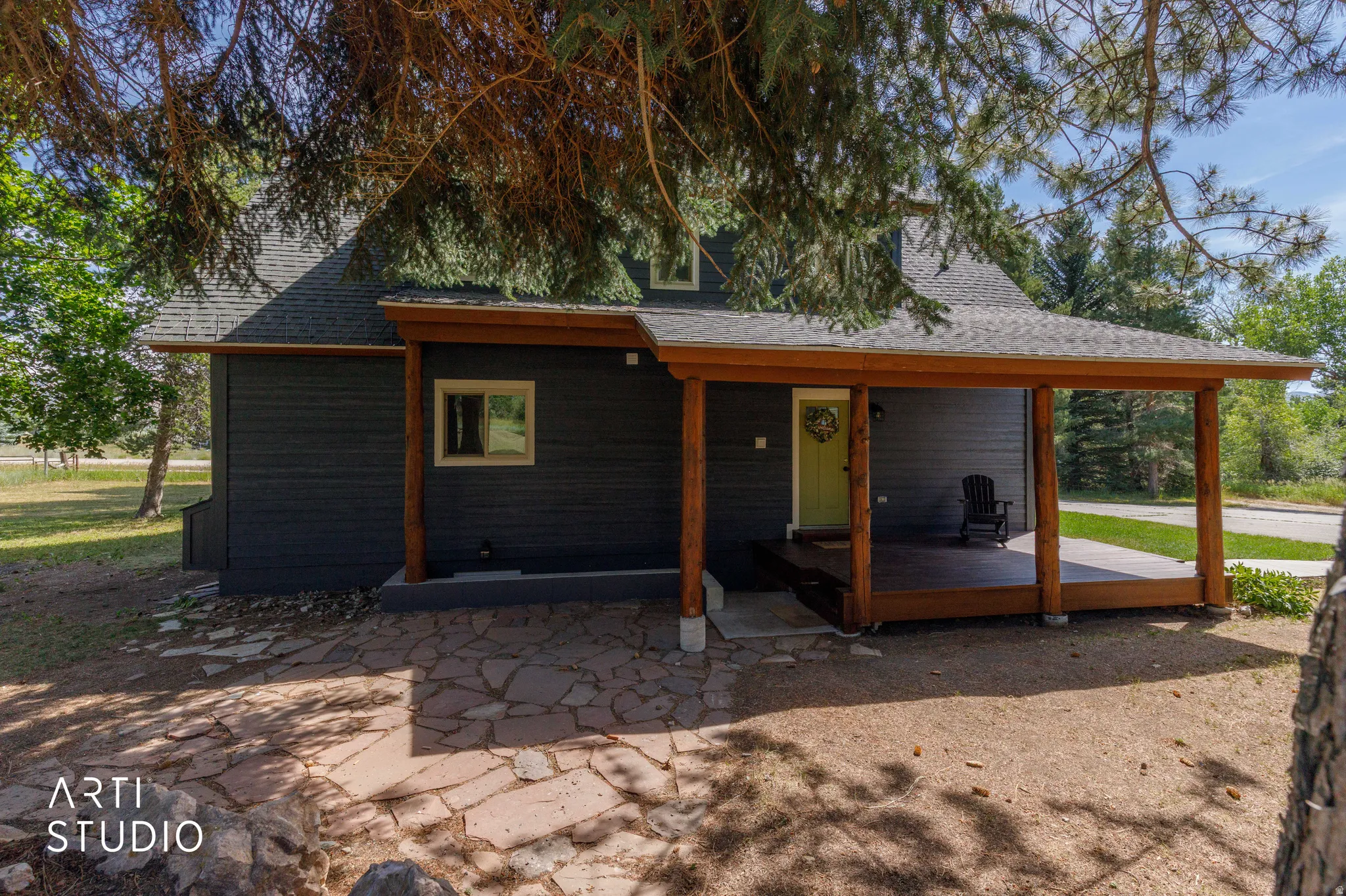 Covered porch featuring wood posts and a wood-finish deck