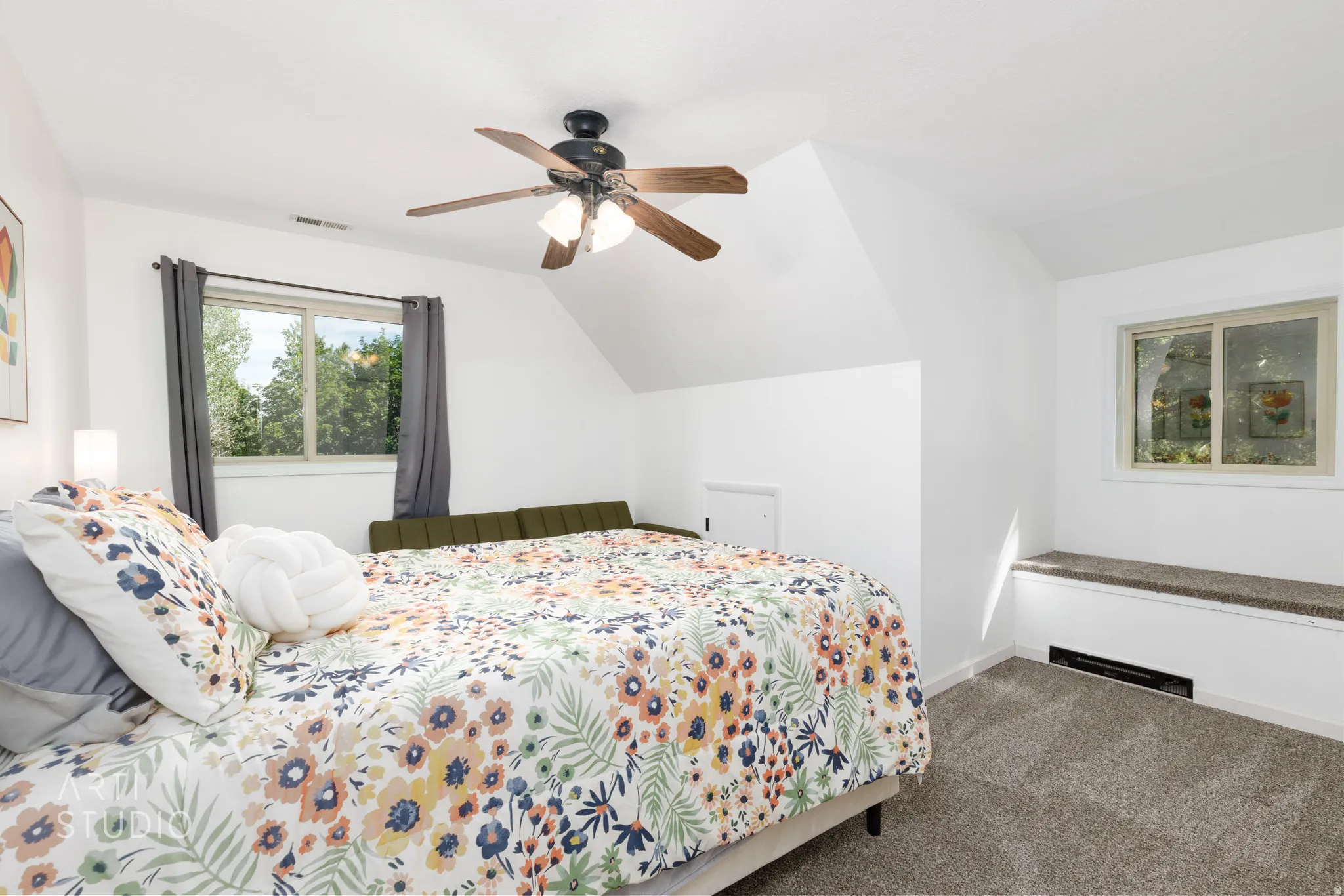 Carpeted flooring, sloped ceiling, ceiling fan with light fixture, window with outdoor scenery, built-in window bench