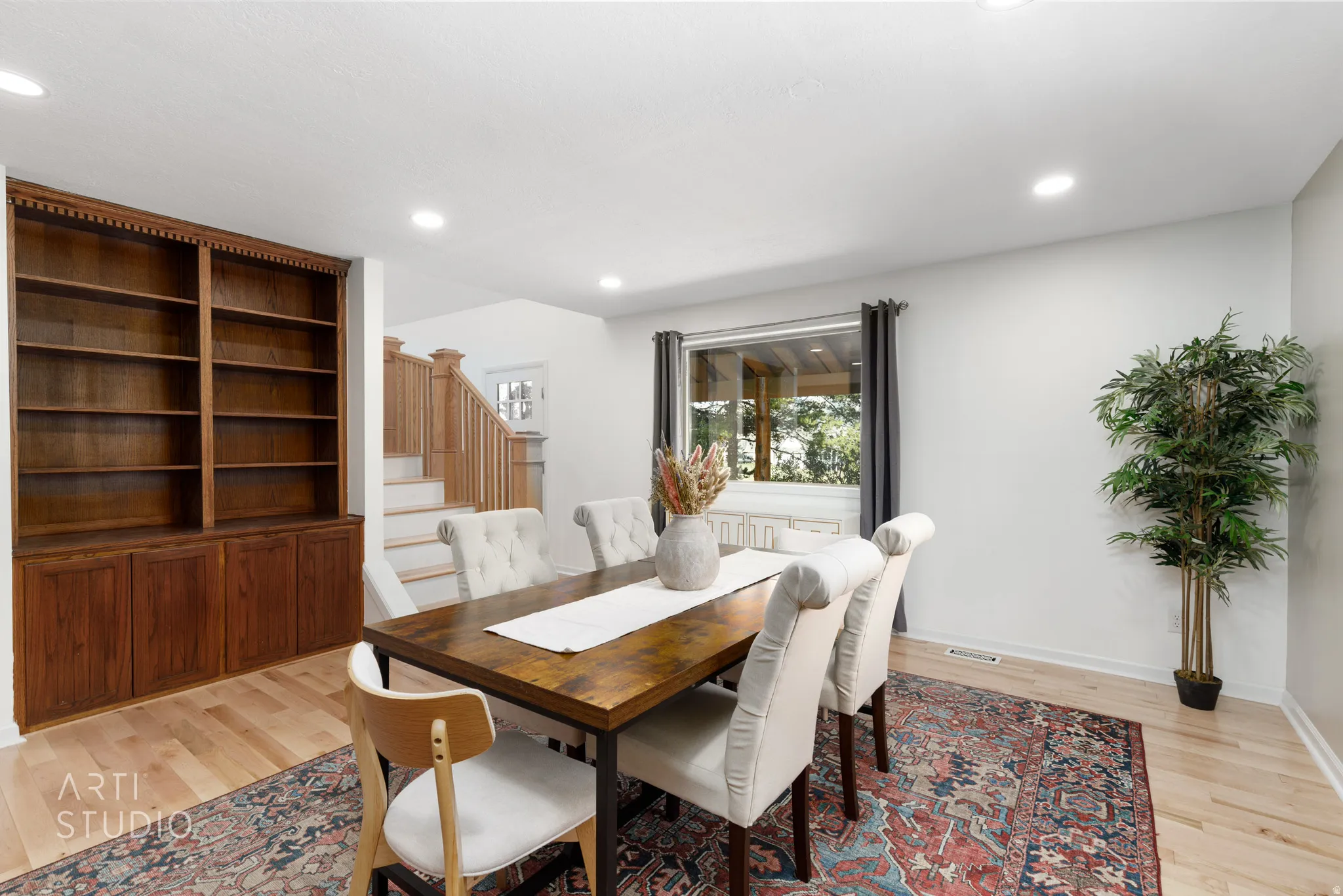 Hardwood flooring throughout, built-in wooden shelving, recessed lighting, and a prominent window