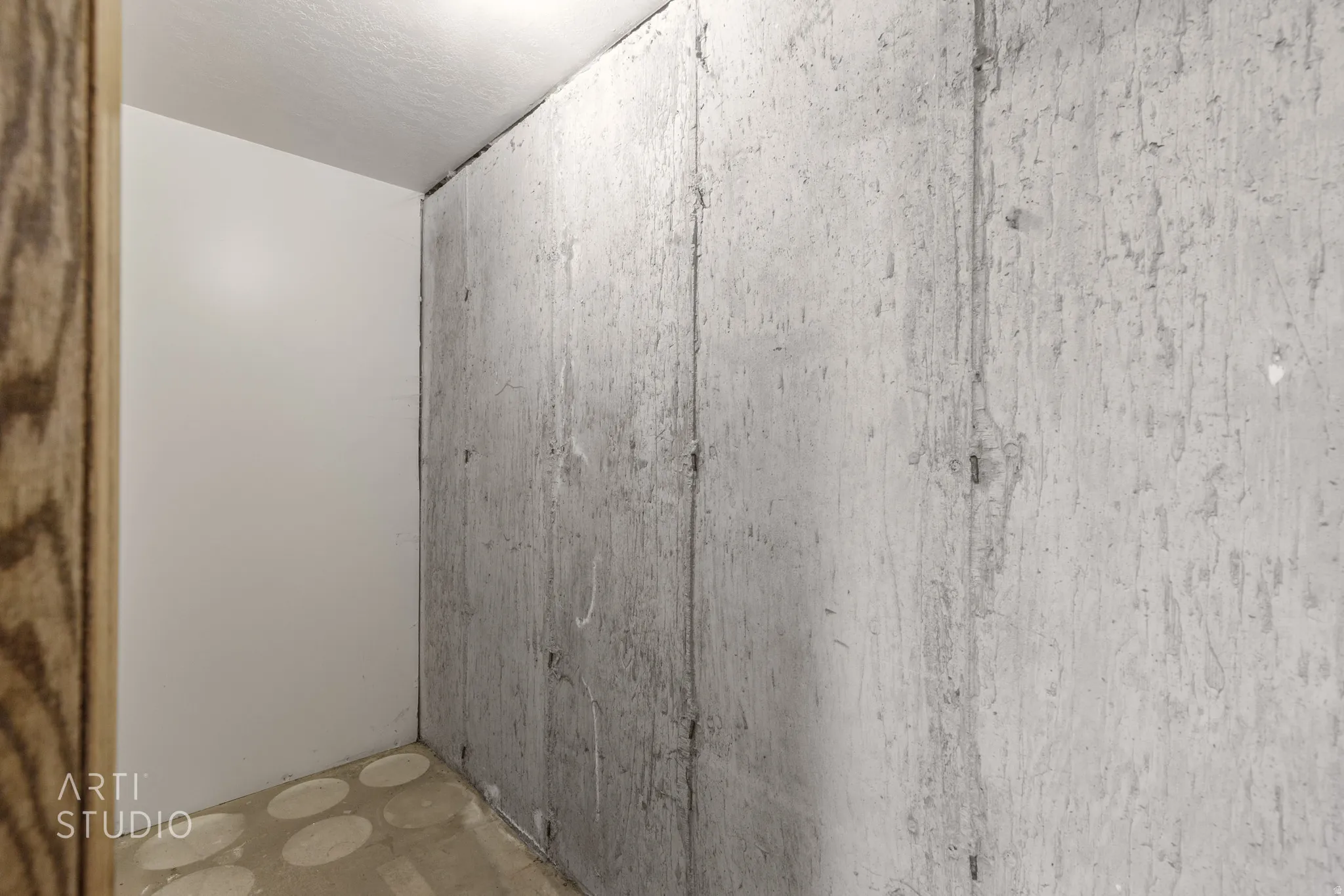 Concrete wall with a wood-grain-finish door frame and light-colored wall panels