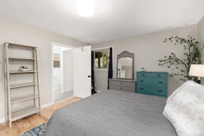 Light wood-finish flooring, neutral wall paint, and a white ceiling-mounted light fixture