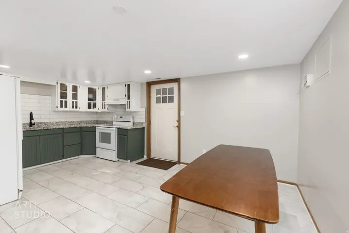 Kitchen featuring white upper cabinetry, dark green lower cabinetry, and light-colored countertops