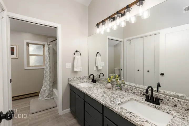 Dual vanity with speckled countertop and matte black fixtures
