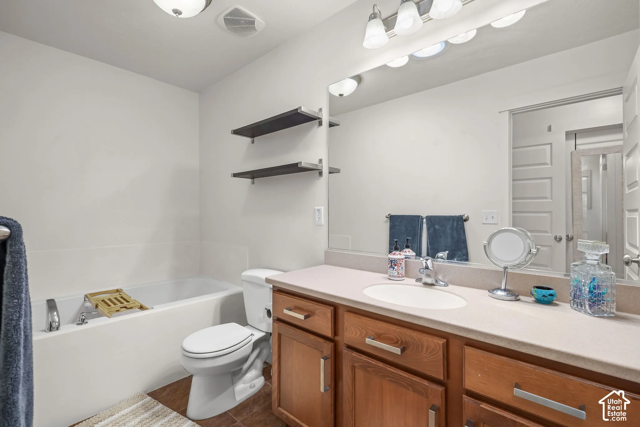 Vanity with wood-finish cabinetry, integrated sink, and extended countertop