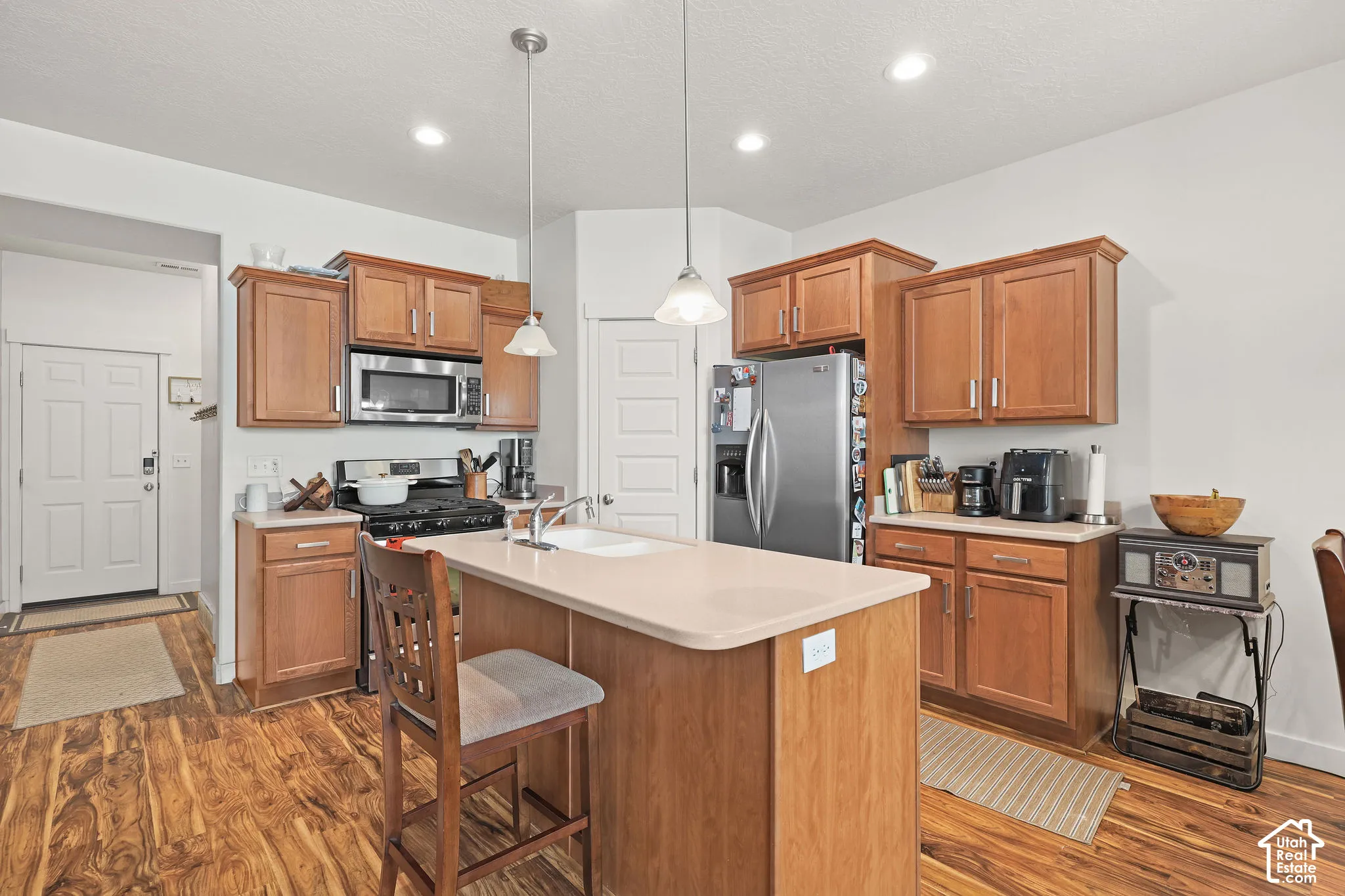 Kitchen featuring wood-finish flooring, recessed lighting, wood cabinetry, and stainless steel appliances