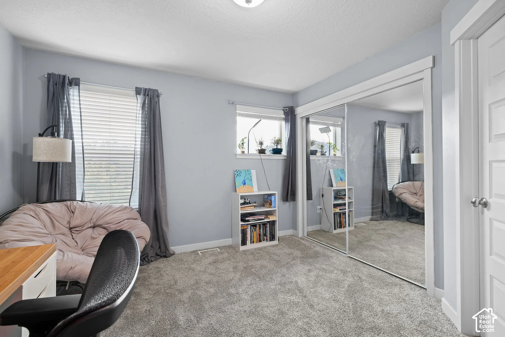 Plush carpet flooring, multiple windows, sliding mirrored closet doors, and recessed lighting