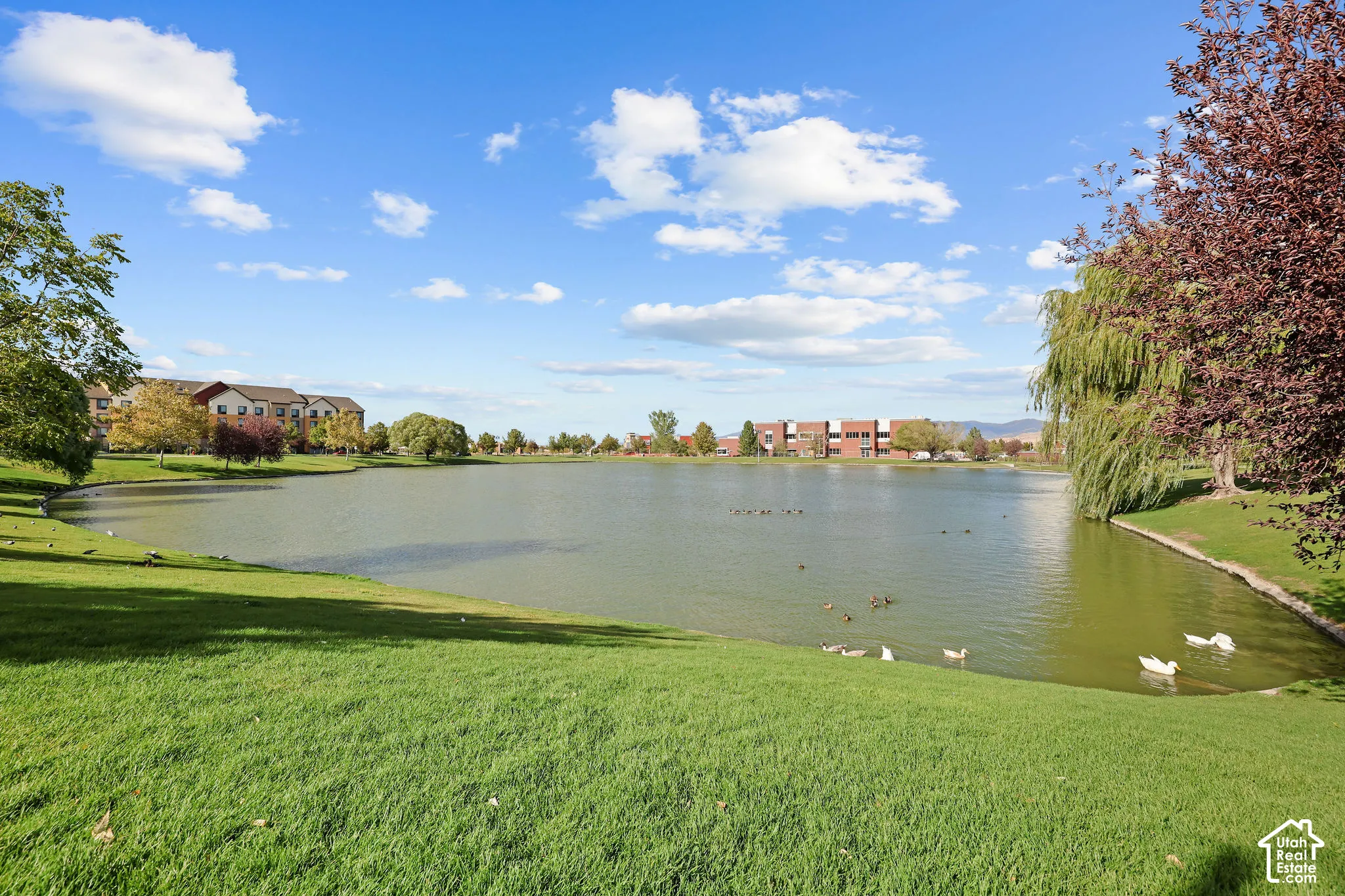 Expansive waterfront property featuring a large lake with surrounding green space and mature trees