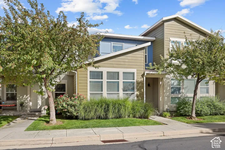 Multi-story exterior with horizontal siding, partial stone detailing, and an integrated covered entry