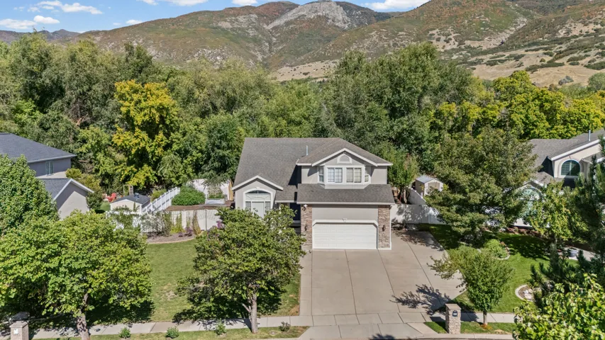 Two-story residence featuring a two-car garage, stone accents, and a sloped roof
