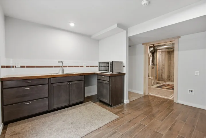 Built-in cabinetry with wood-finish countertops and a stainless steel sink
