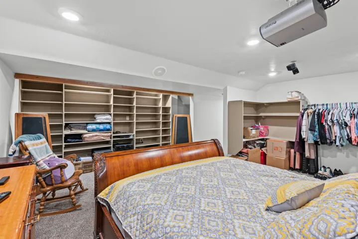 Wall-to-wall built-in shelving, recessed lighting, and ceiling-mounted projector