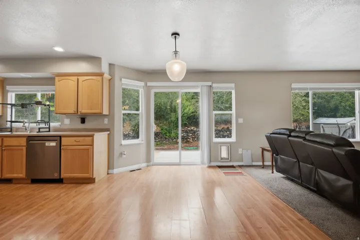 Open-concept living space with wood-finish flooring, recessed lighting, and a sliding glass door