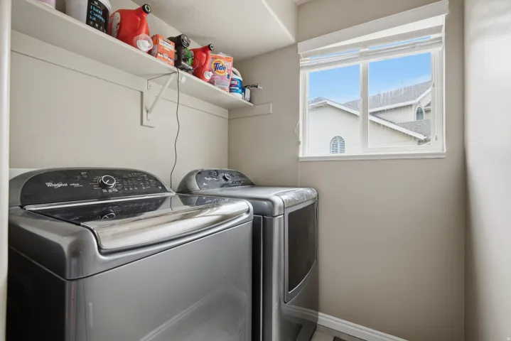 Built-in shelving for storage, a rectangular window with blinds, and light-toned wall paint