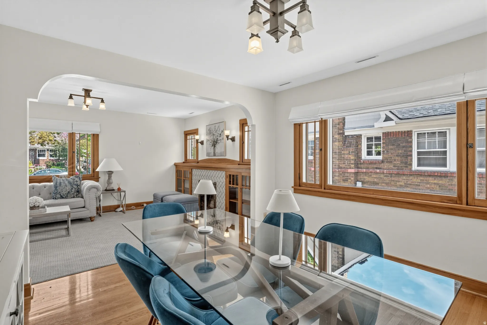 Hardwood flooring, arched doorway, wood-framed windows, and a built-in cabinet with decorative paneling