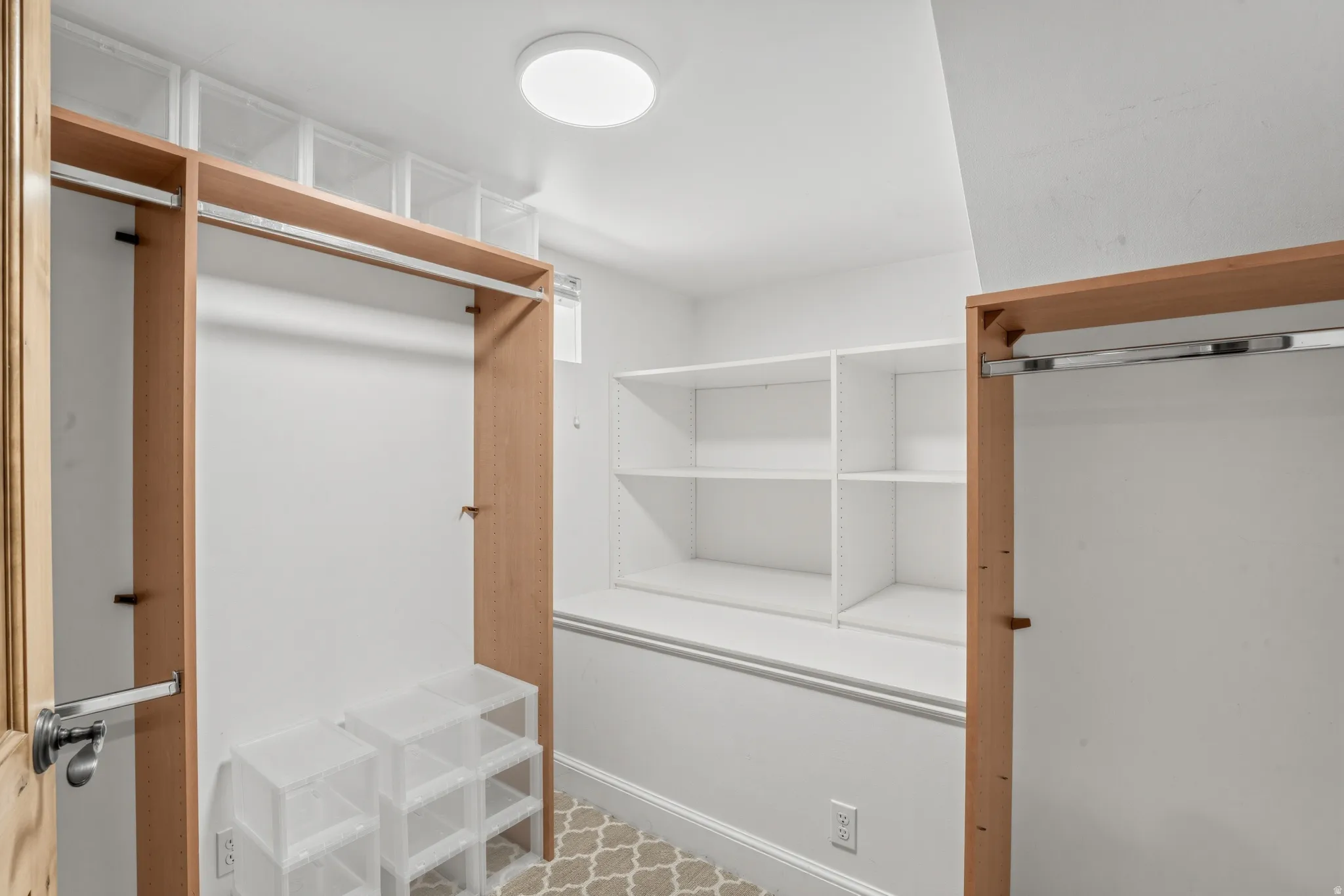 Custom closet system with integrated shelving, wood-tone framing, and flush-mount lighting