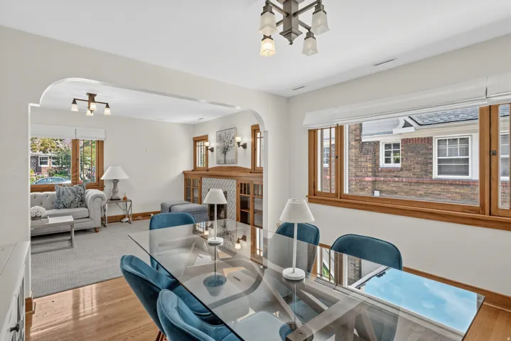 Hardwood flooring, arched doorway, wood-framed windows, and a built-in cabinet with decorative paneling