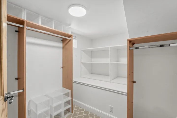 Custom closet system with integrated shelving, wood-tone framing, and flush-mount lighting