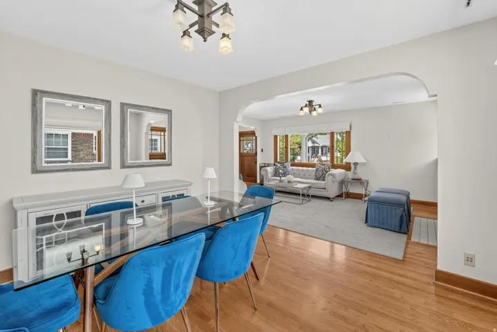 Hardwood flooring extending throughout, an arched doorway, and overhead lighting fixture