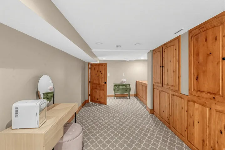 Wall-to-wall carpeting with geometric pattern, wood-paneled built-in cabinetry, recessed ceiling lighting, and solid wood interior doors