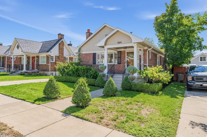 Brick exterior with a gabled roofline, covered front porch, and manicured landscaping