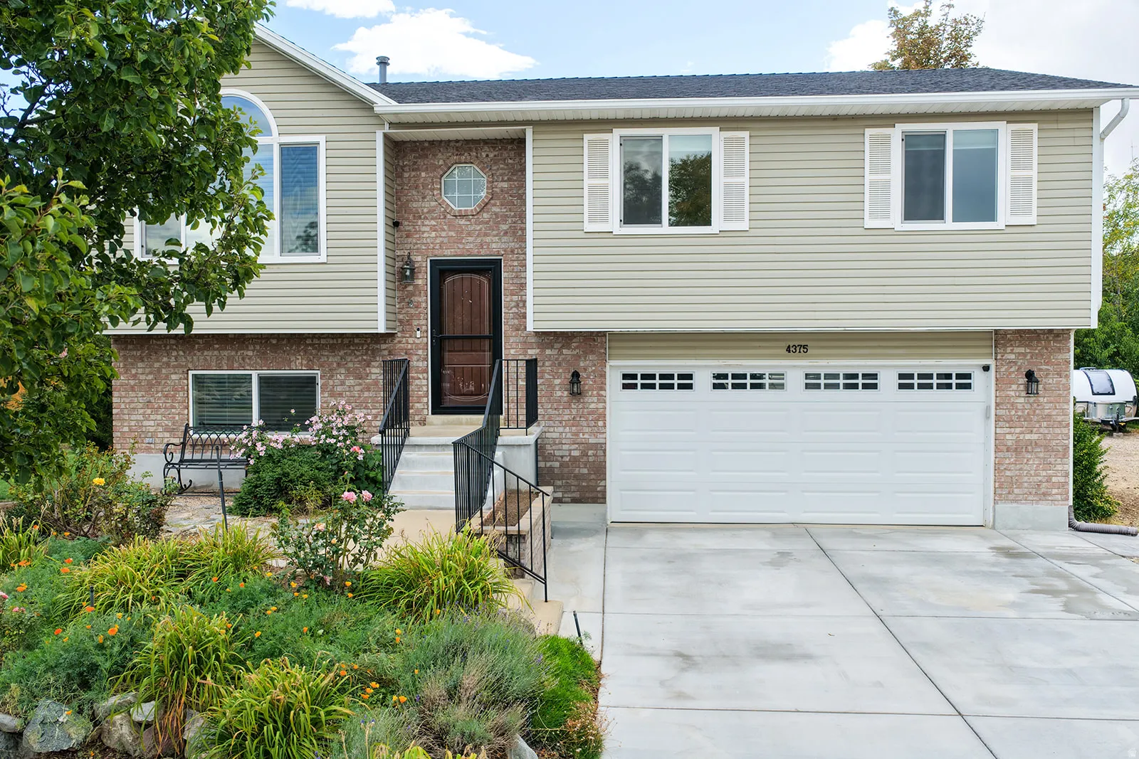 Brick and siding exterior with a prominent arched window