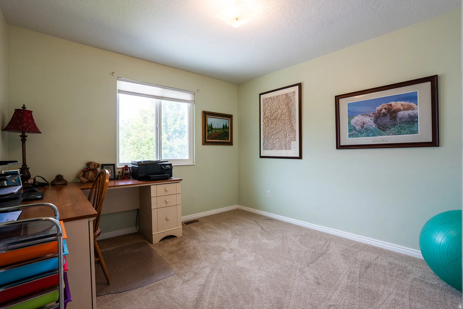 Recessed lighting illuminates a room featuring a single window and neutral-toned carpeting