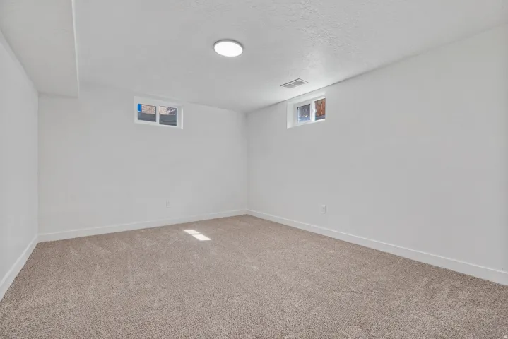Recessed lighting, light gray carpeting, and white painted walls