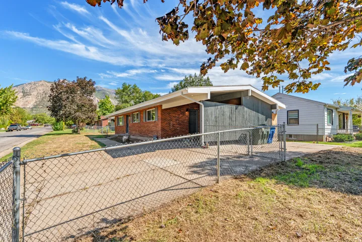 Brick exterior with a peaked roofline, front-facing windows, and a concrete driveway