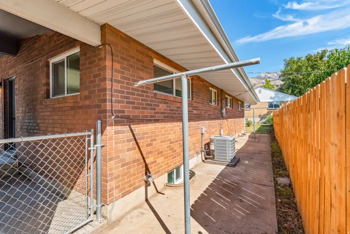 Brick exterior with an air conditioning unit and a privacy fence